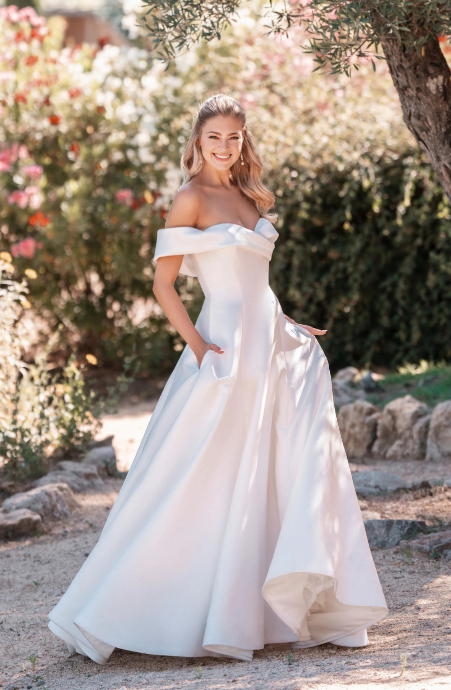 Off-the-shoulder pearlescent Mikado A-line wedding gown with a sleek, structured silhouette.
