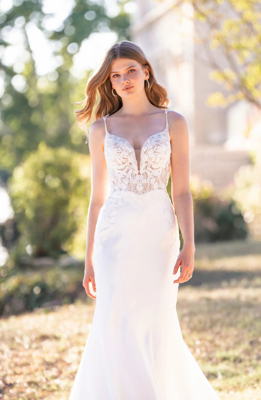 Sheath-style stretch satin wedding dress with beaded lace appliques and an illusion hemline.