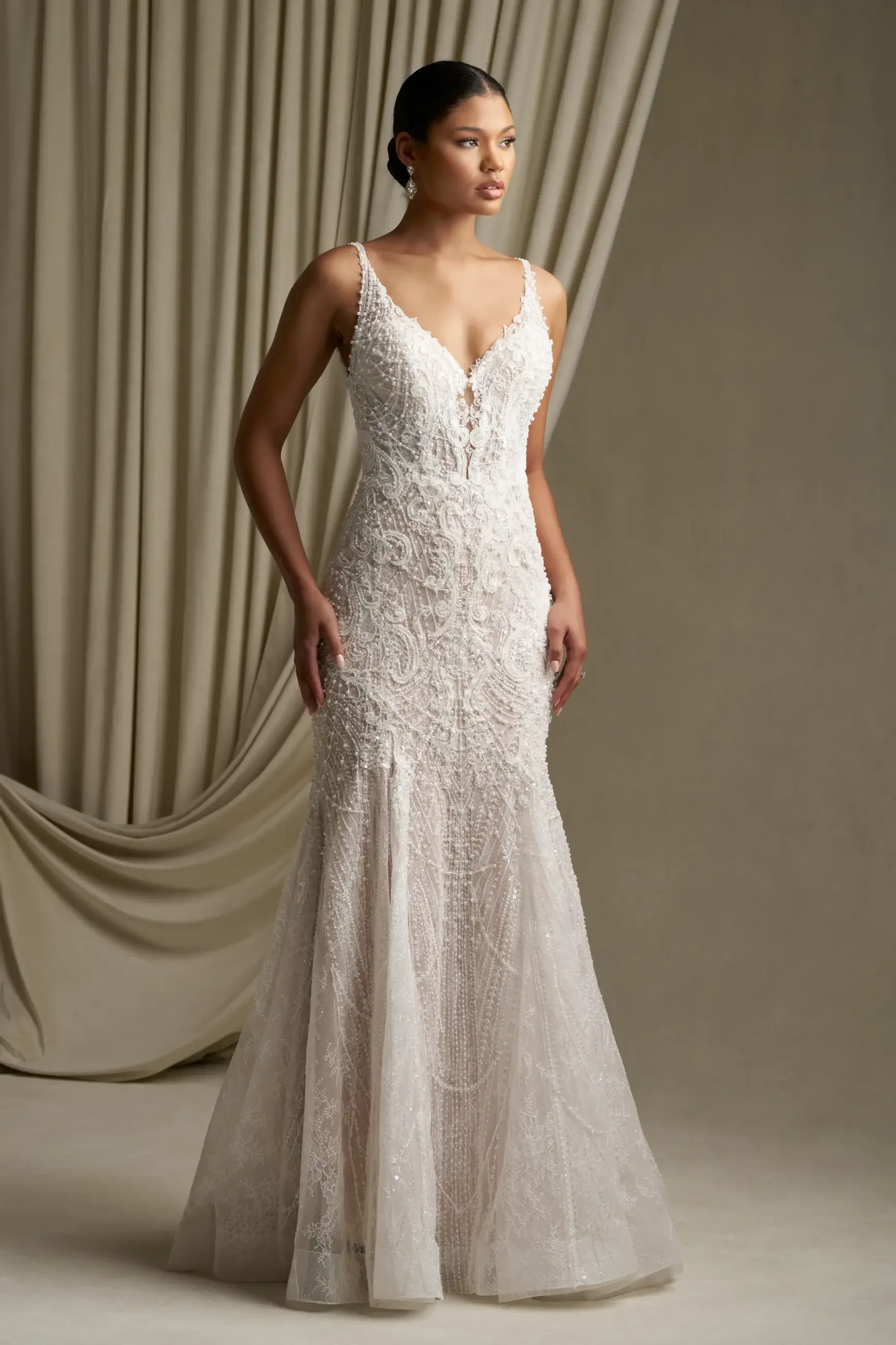 model is wearing a sleeveless fit and flare lace wedding dress
