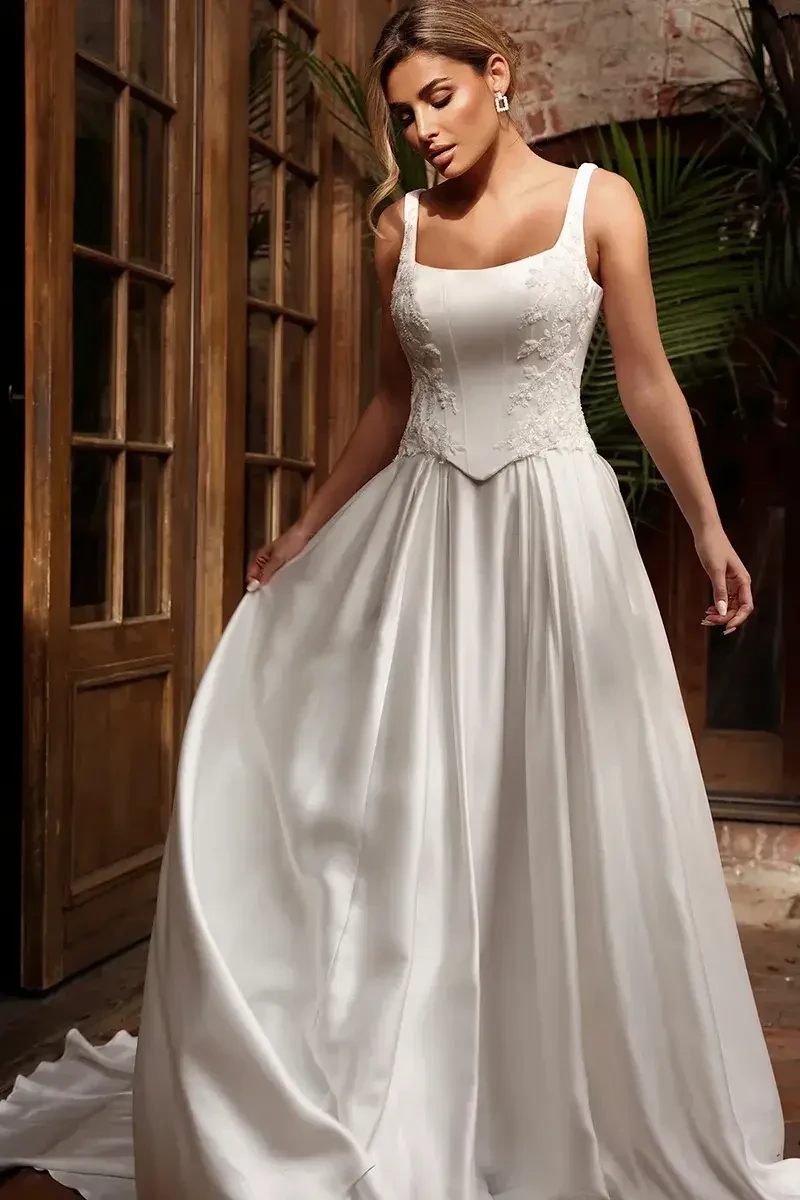 model is wearing a sleeveless basque waist wedding gown