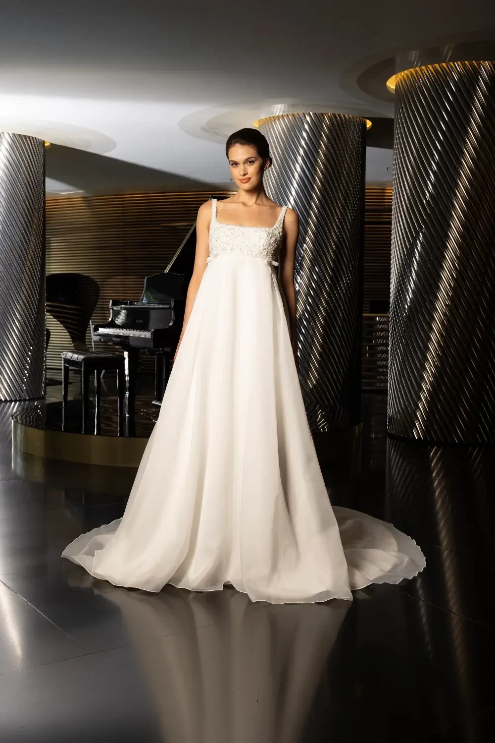 model is wearing a sleeveless empire waist bridal gown
