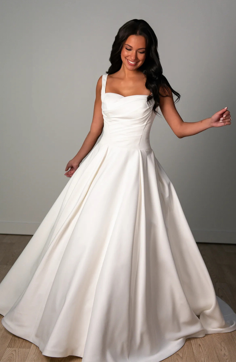 model is wearing a sleeveless ball gown wedding dress